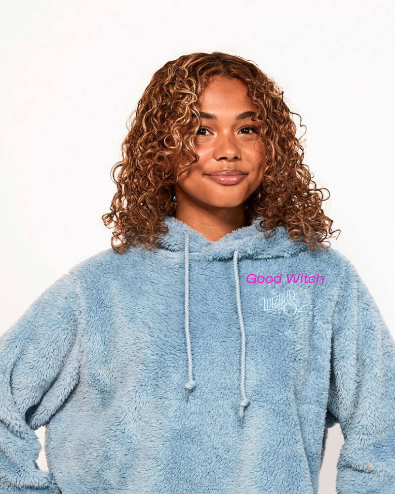 Person wearing a blue hoodie with 'Good Witch' text on a white background