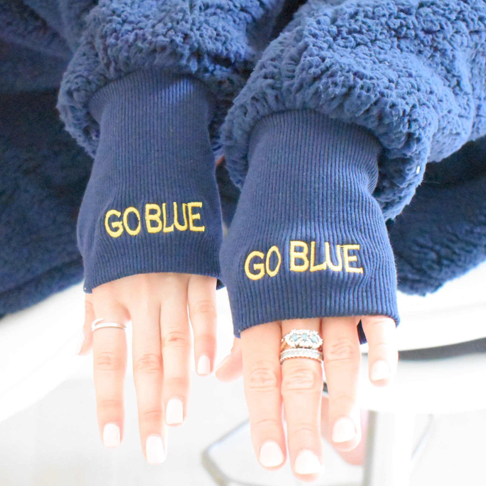 Blue ribbed cuffs with thumbholes with 'GO BLUE' text on each cuff