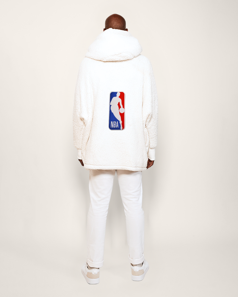 Person wearing a white hoodie with NBA logo on a plain background
