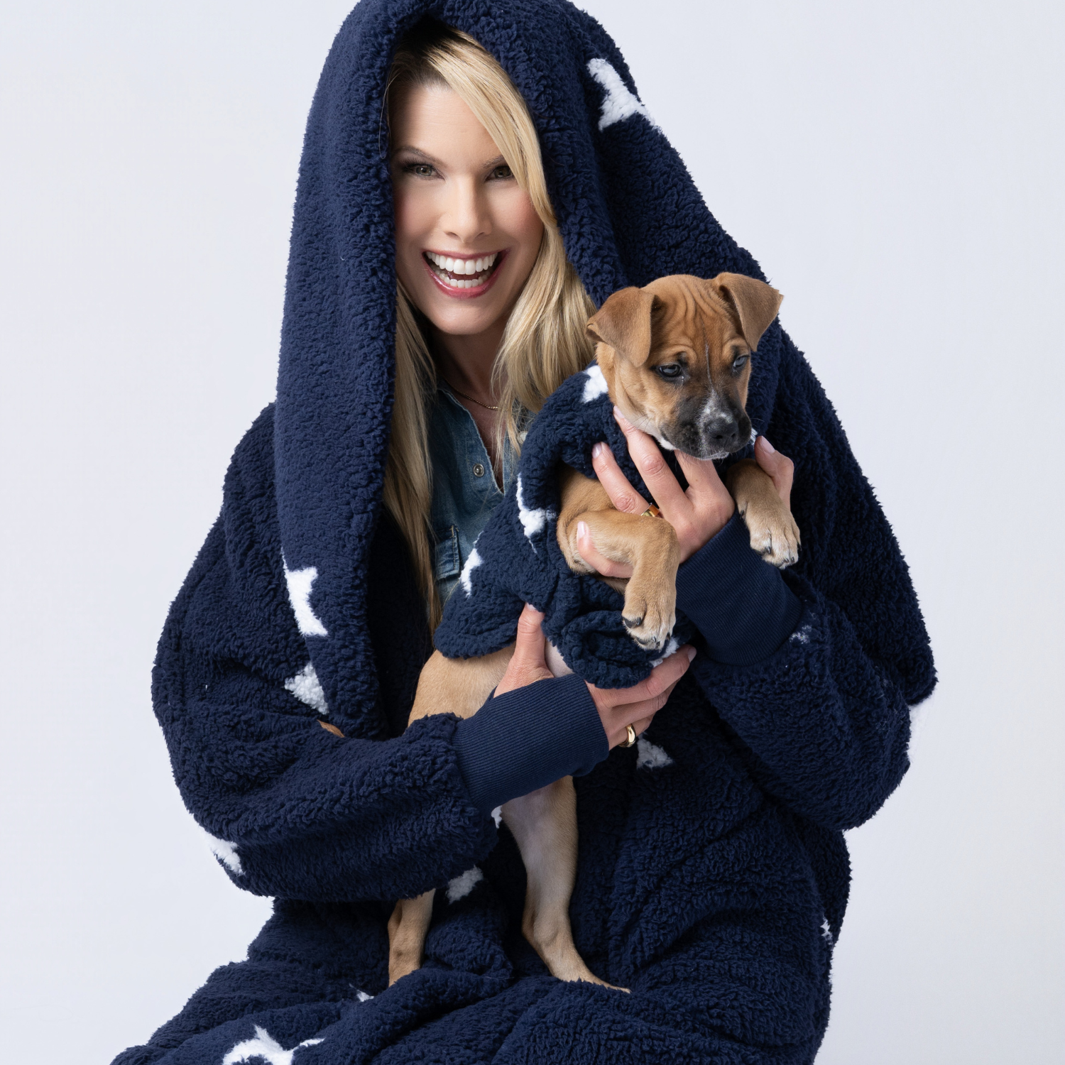 person wearing navy with white star sherpa lounger and dog wearing matching pet jacket