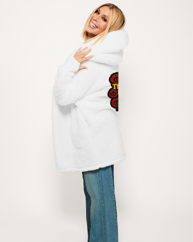 Person wearing a white coat with a floral design on a plain background