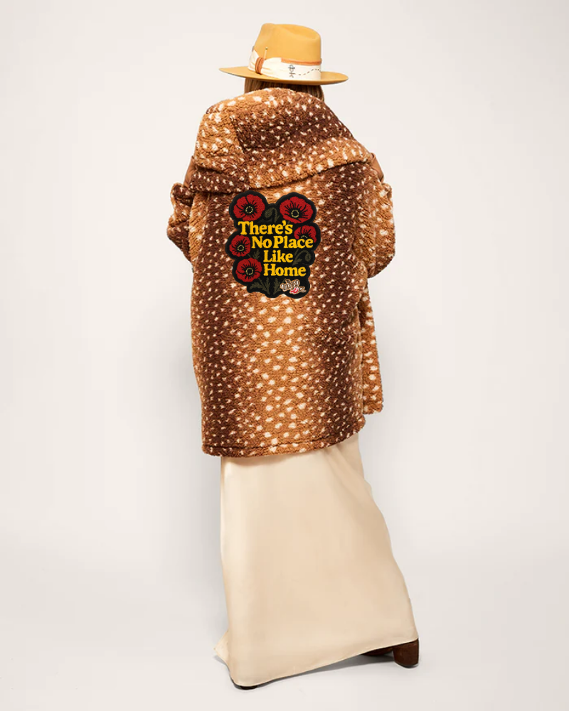 Person wearing a brown jacket with a colorful graphic and text on a white background