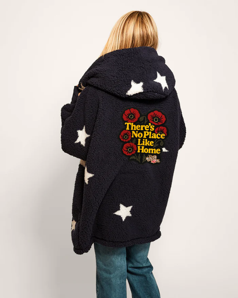 Person wearing a black hoodie with star patterns and text on the back against a white background