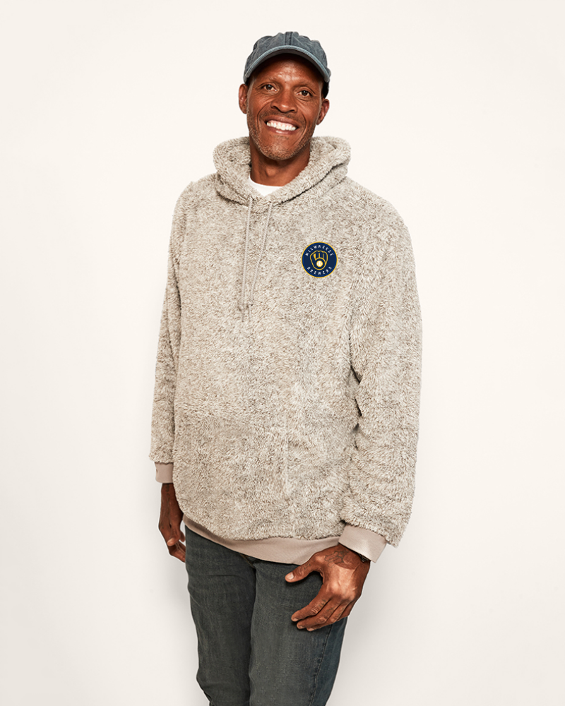 Man wearing a grey hoodie with a logo on a white background