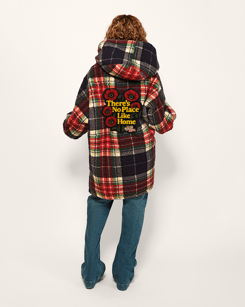 Person wearing a plaid jacket with text on the back, standing against a white background