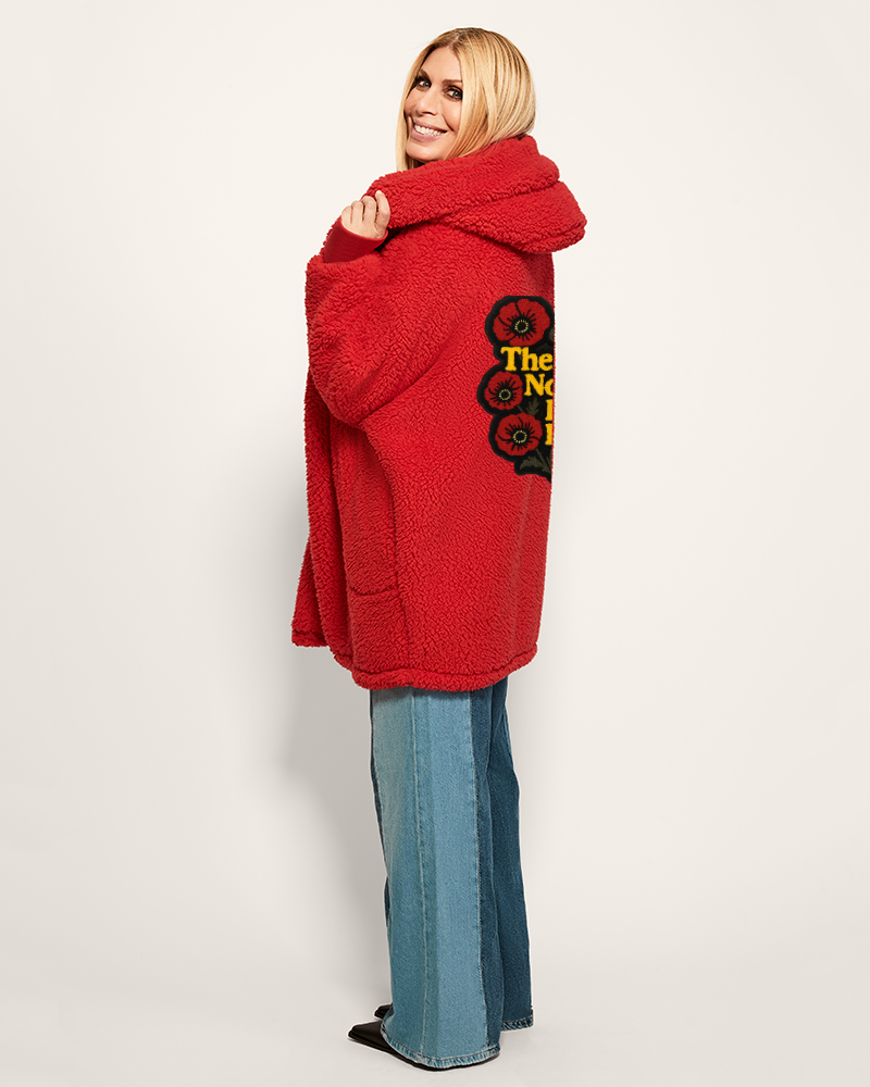 Person wearing a red oversized sweater with a graphic design on a white background