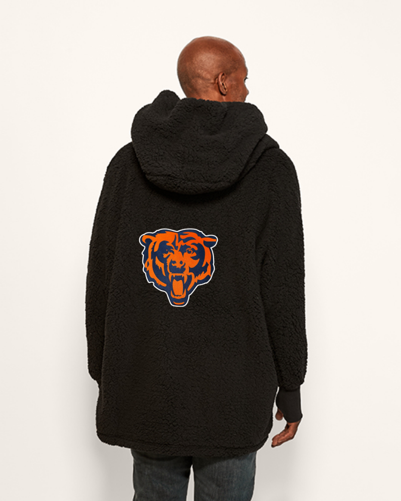 Person wearing a black hoodie with a logo on the back against a white background