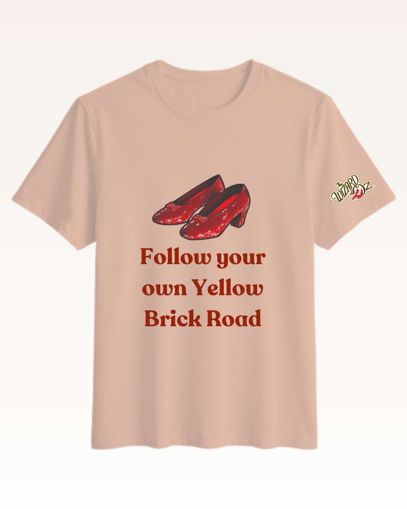 Beige t-shirt with red shoes and text 'Follow your own Yellow Brick Road' on a white background