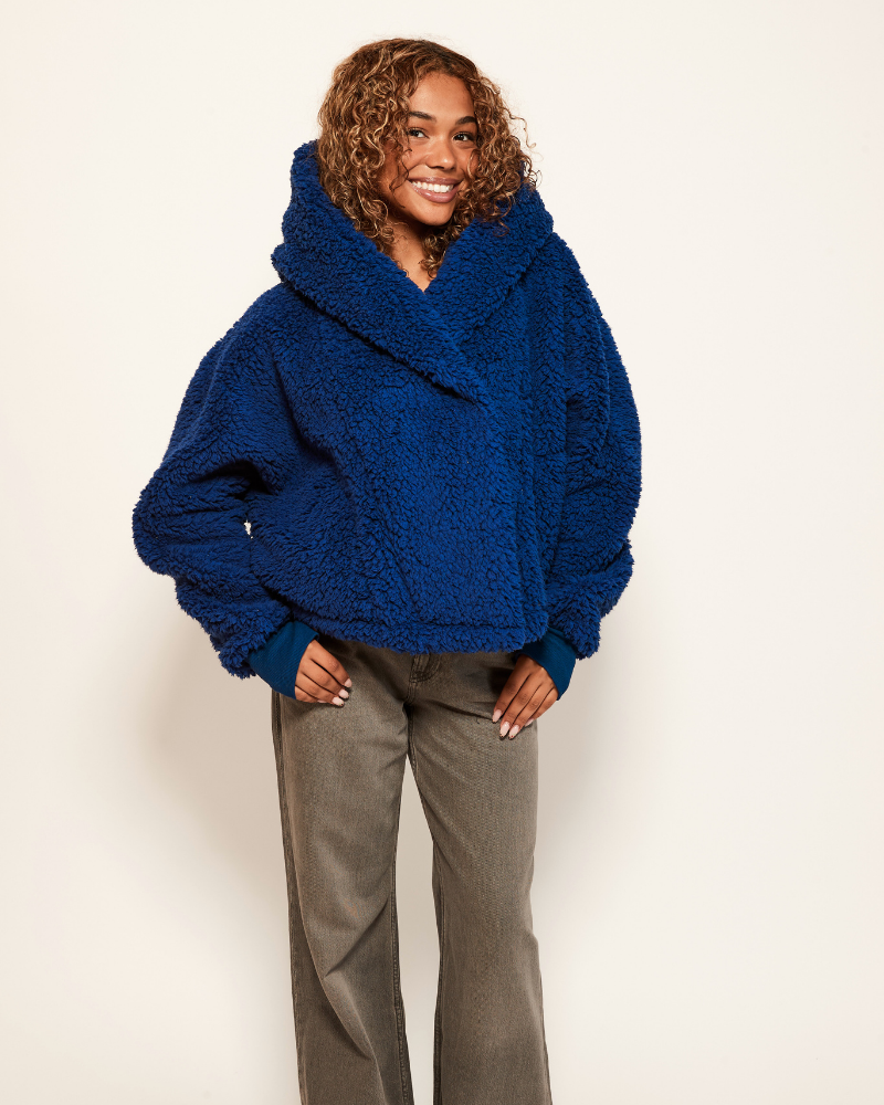 Person wearing a blue oversized sweater against a white background