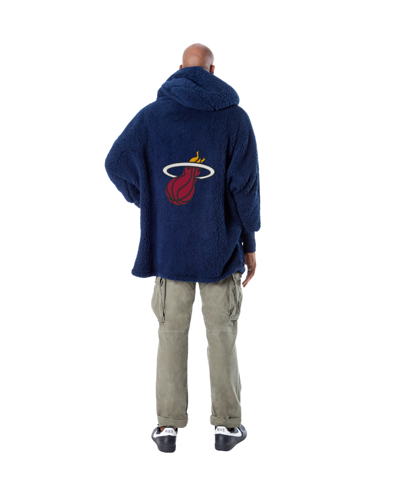 Person wearing a navy lounger with a miami heat logo on the back, standing against a white background