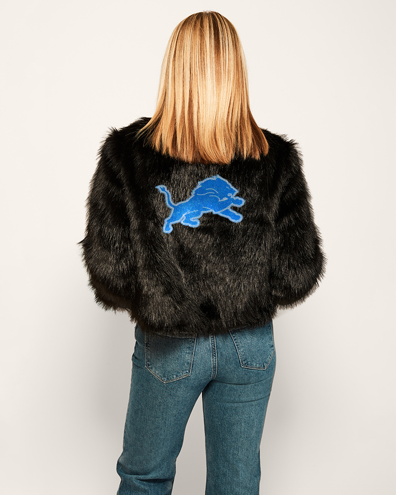 person wearing black faux fur jacket with blue detroit lions logo