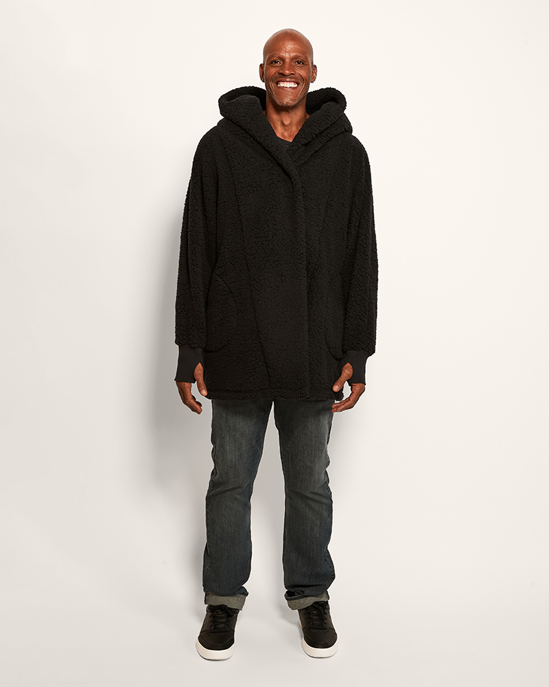 Man wearing a black hoodie and jeans on a white background