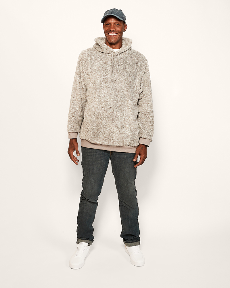 Man wearing a gray hoodie and jeans on a white background