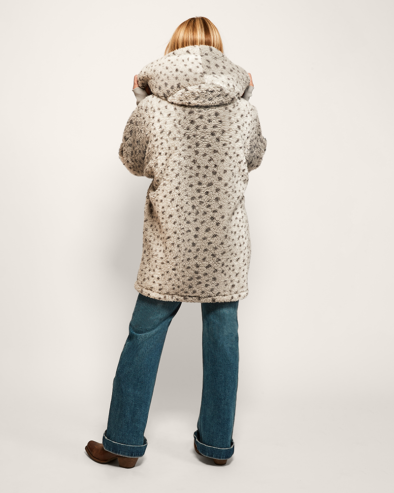 Person wearing a patterned coat on a plain background