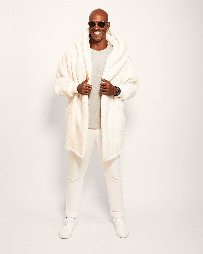 Man wearing a white robe and sunglasses on a plain background