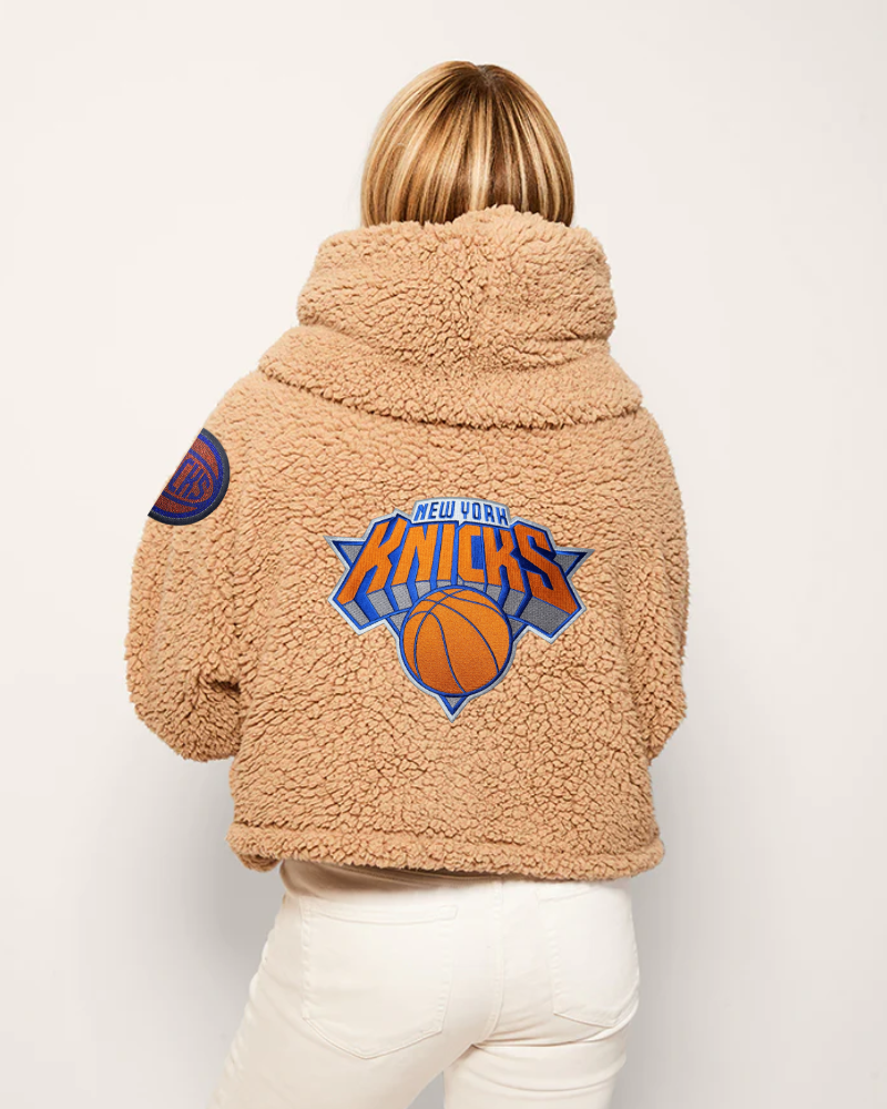 Person wearing a tan sherpa jacket with New York Knicks logo on the back