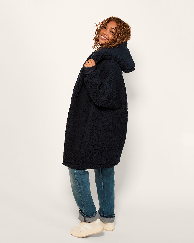 Person wearing a dark blue coat on a white background