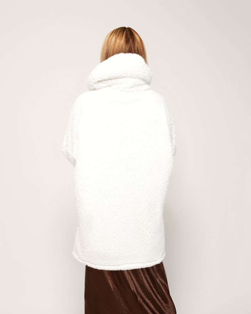 Person wearing a white coat with a plain background