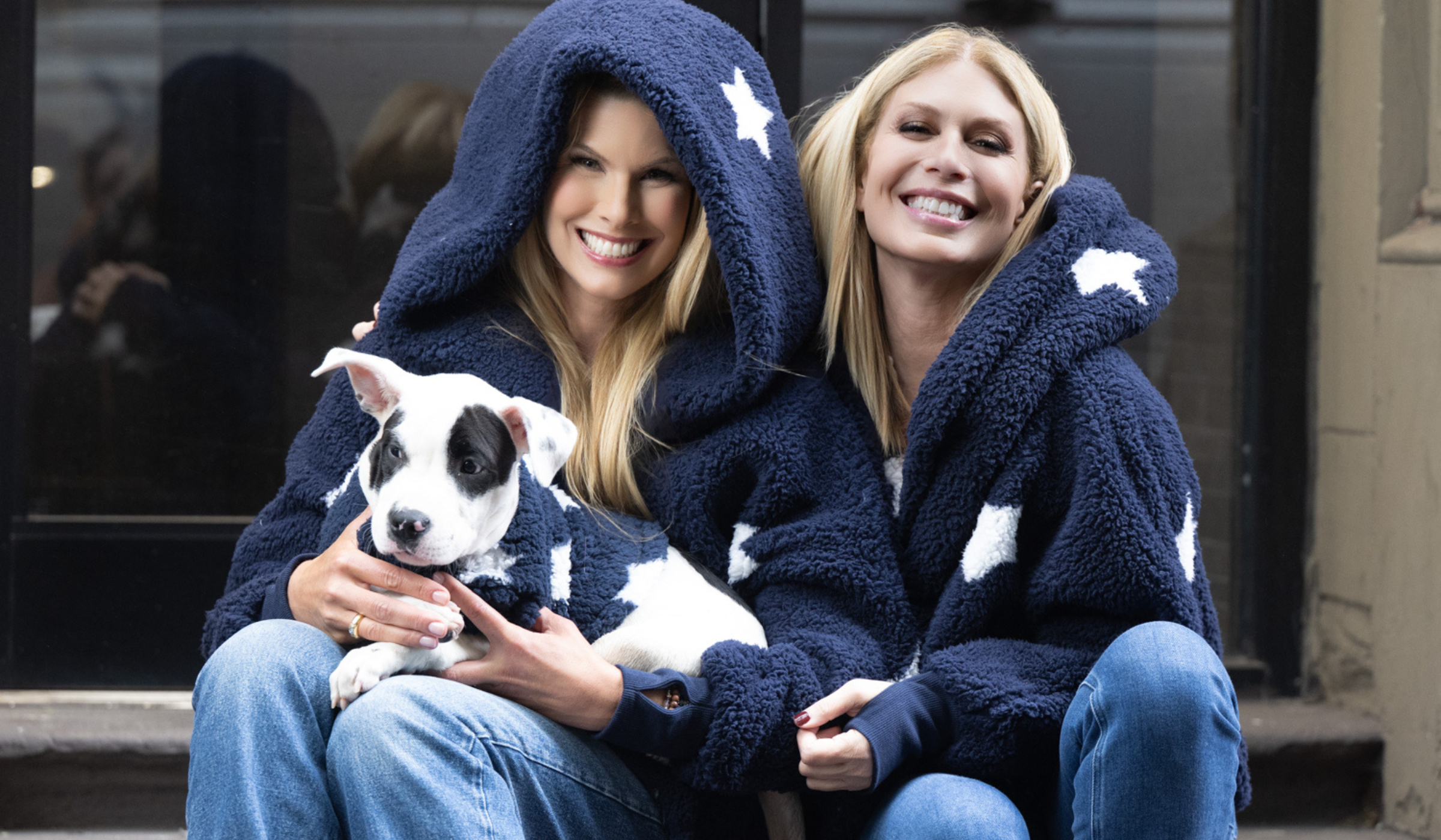 Two women wearing navy with white star sherpa lounger with a dog wearing a matching pet jacket