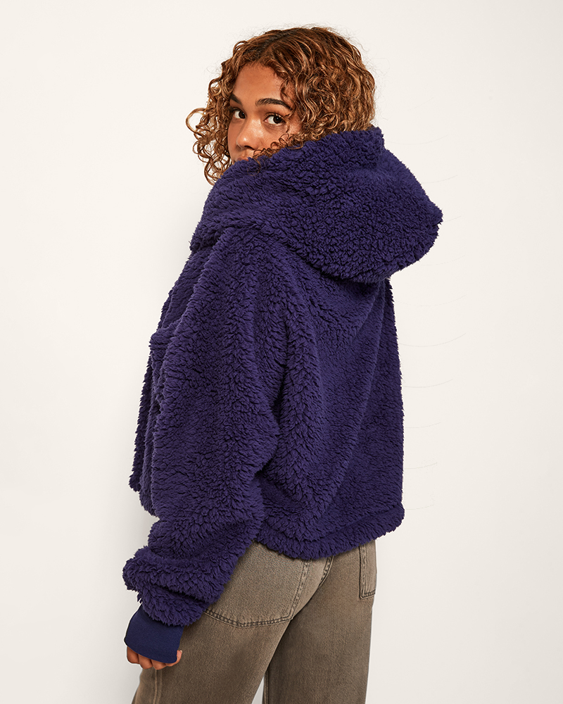 Person wearing a purple sherpa jacket on a white background