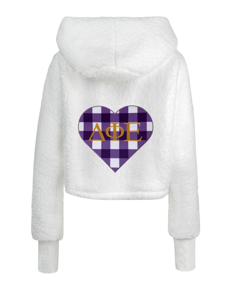 White sherpa fleece cropped hoodie with a purple and white checkered heart graphic on the back featuring the Greek letters Delta Phi Epsilon in gold.