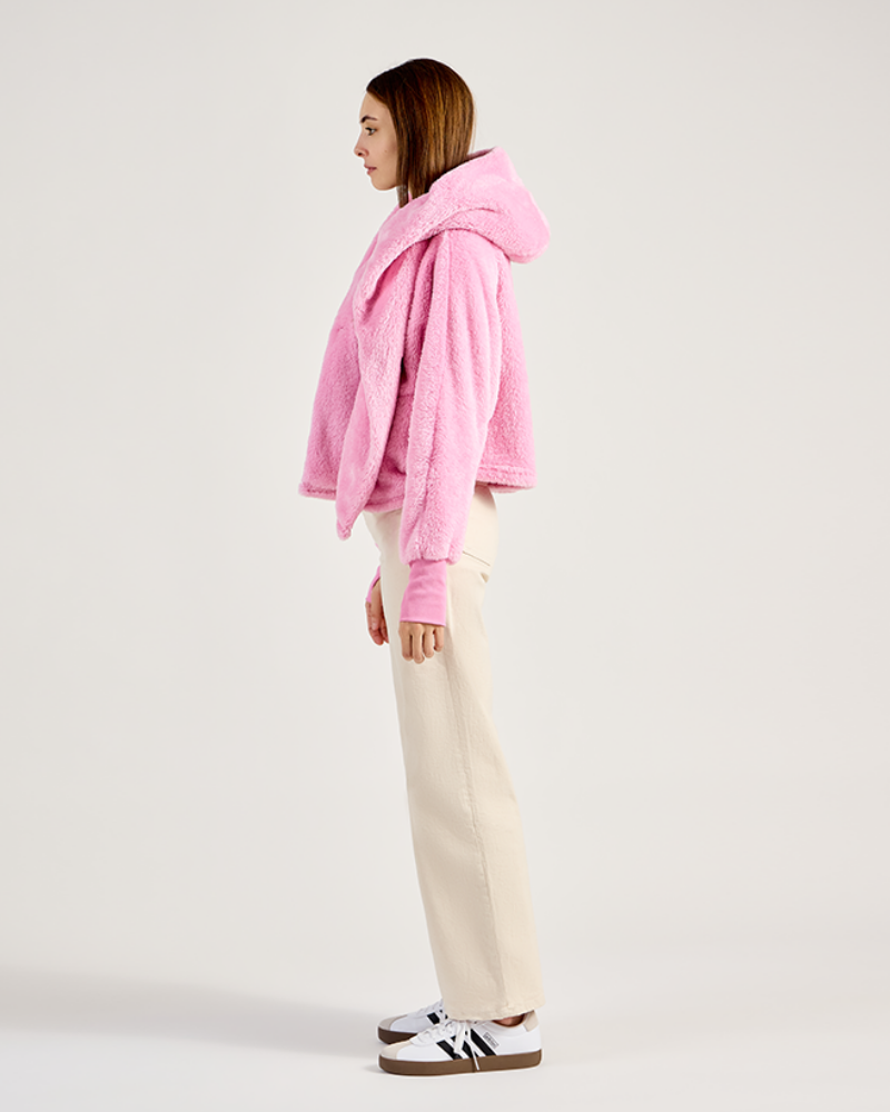 Person wearing a pink hoodie and beige pants on a white background|Model: 5'11" in size XS/S