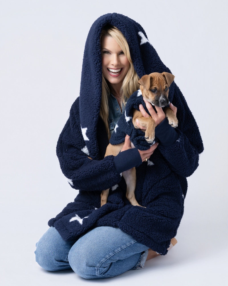person wearing sherpa in navy with starts holding dog wearing matching sherpa pet jacket