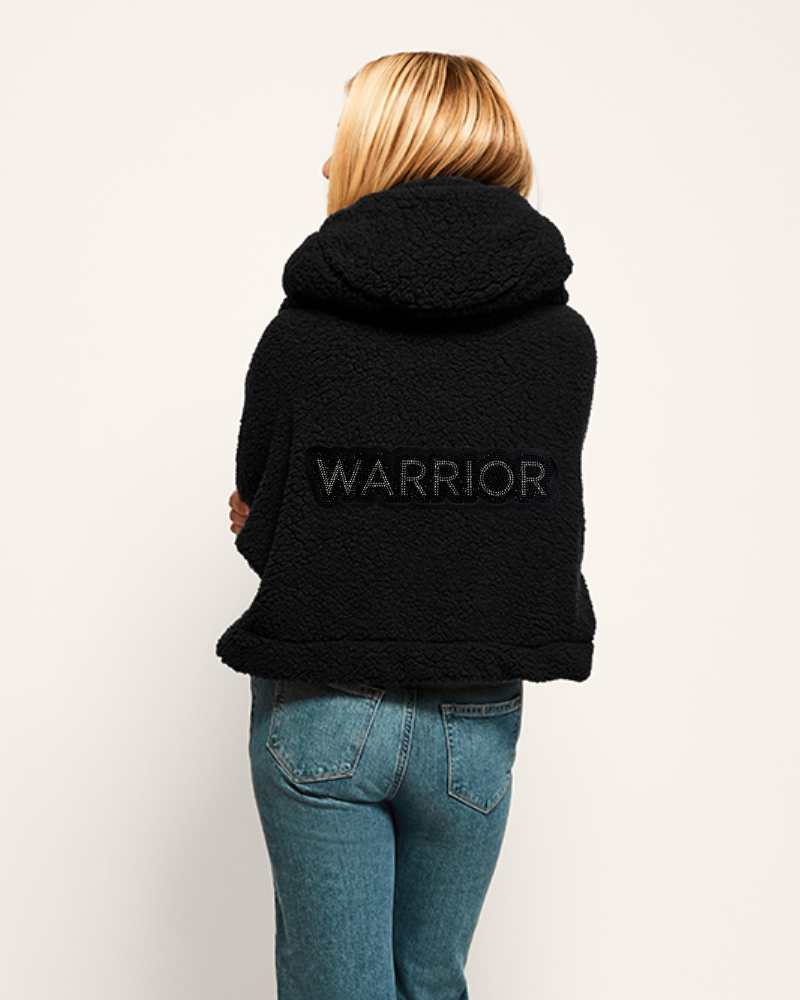 Person wearing a black hoodie with 'WARRIOR' text on the back, standing against a plain background.