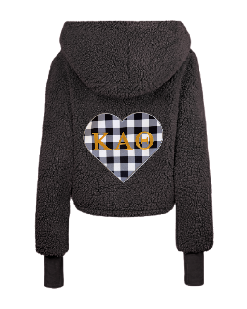 A dark gray sherpa fleece cropped hoodie shown from the back, featuring a large heart-shaped black and white buffalo plaid graphic on the back with the letters 'Kappa Alpha Theta' in gold across the center.