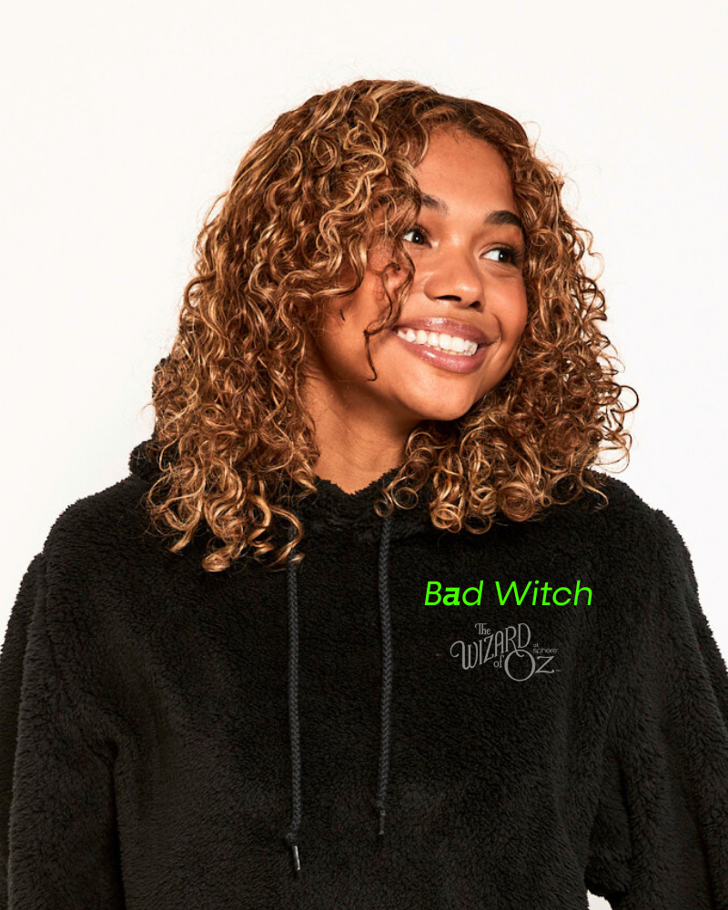 Person wearing a black hoodie with 'Bad Witch' text, inspired by 'The Wizard of Oz'.
