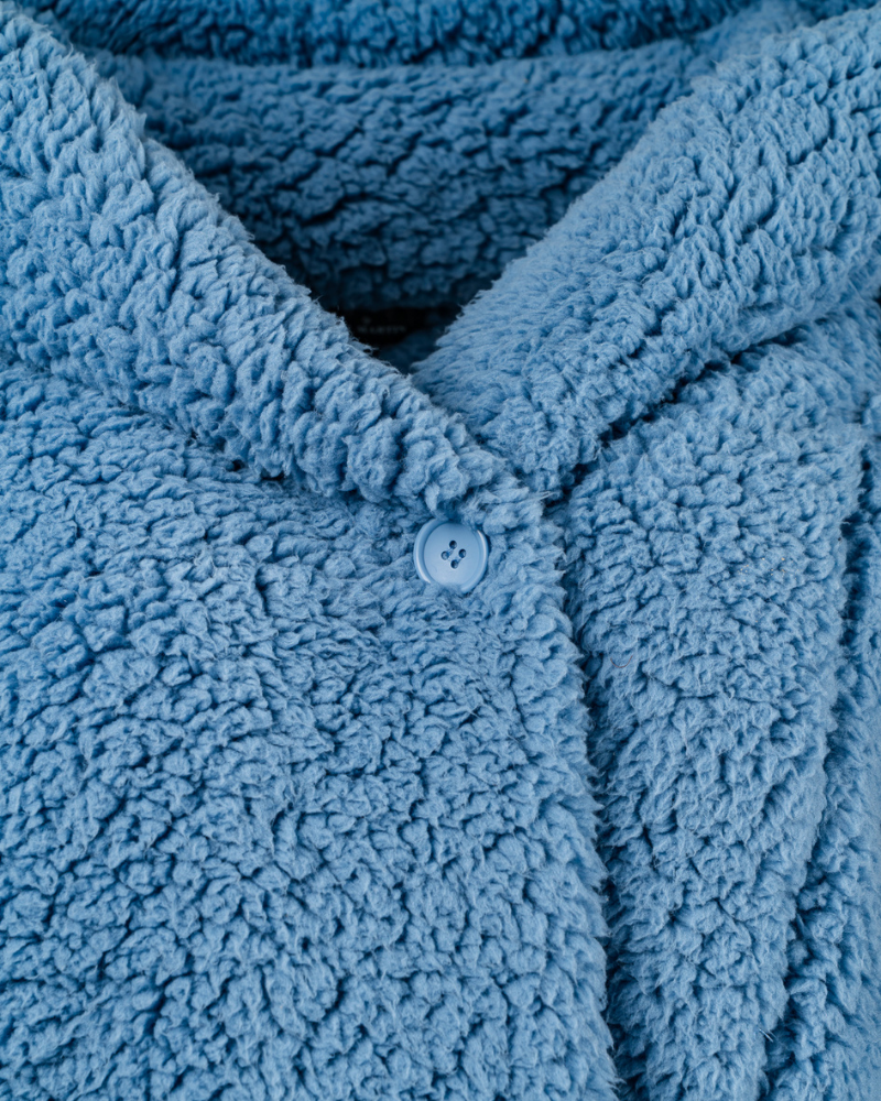 Close-up of a blue textured fabric with a button