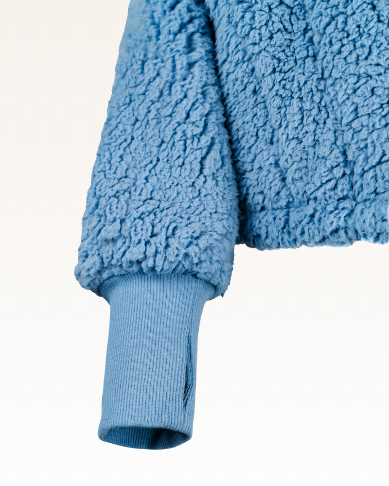 Close-up of a blue fleece jacket on a white background