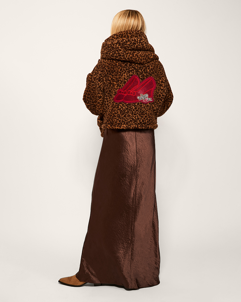 Person wearing a leopard print coat with a red logo on a white background