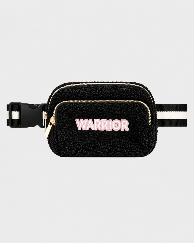 A black sherpa fanny pack with a black and white striped adjustable strap, featuring a gold zipper and the word 'WARRIOR' in pink letters on the front.