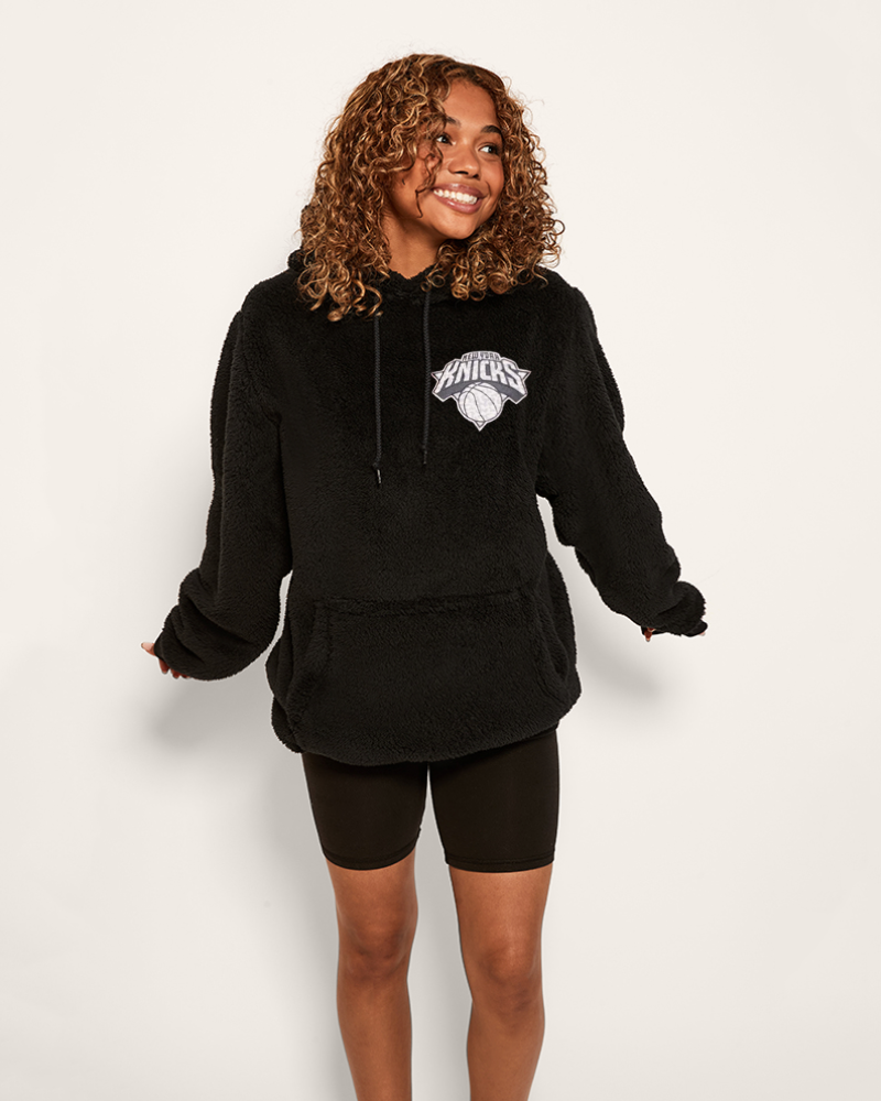 girl wearing black hoodie with leopard printed new york knicks logo on upper left chest