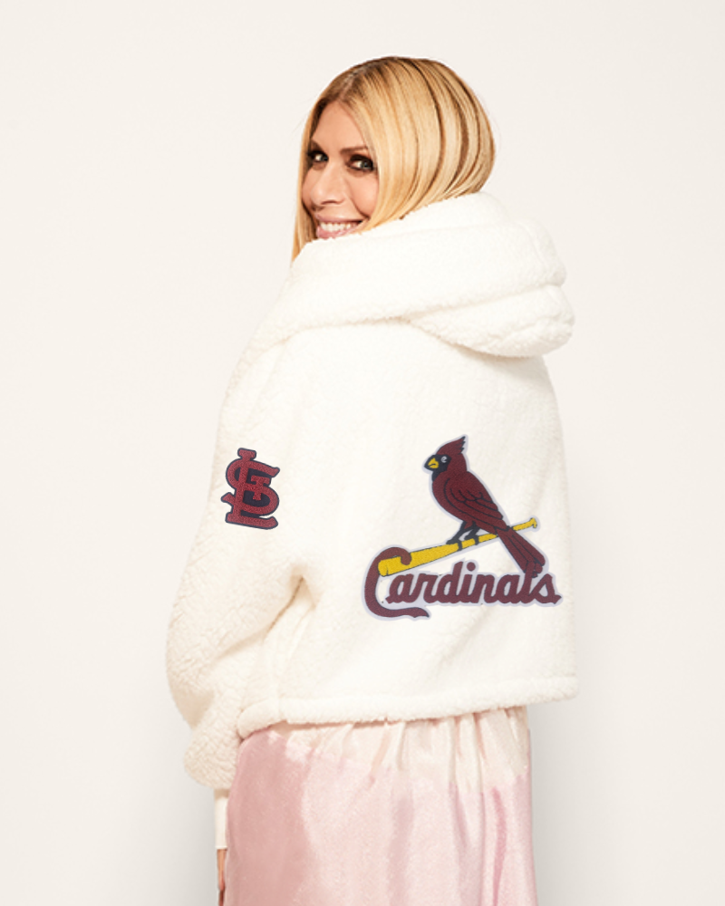 Person wearing a white hoodie with a Cardinals logo on back and sleeve against light background