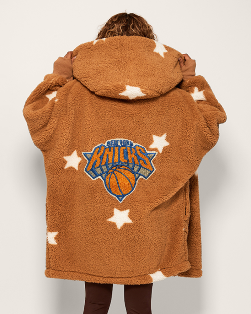 tan fleece jacket with New York Knicks logo and star patterns on a plain background