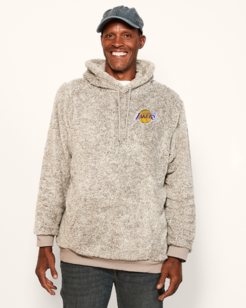 Man wearing a grey sherpa hoodie with a lakers logo on a white background