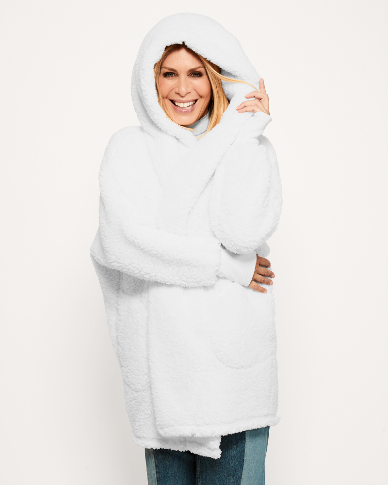 Person wearing a white hooded coat on a plain background