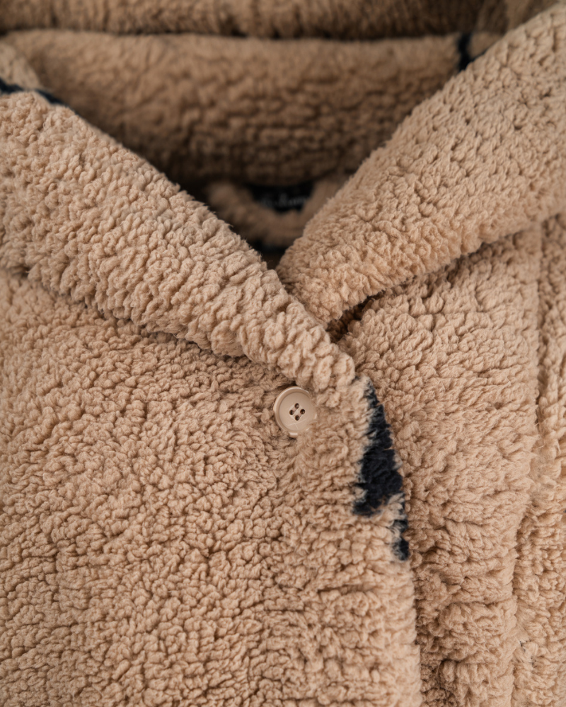 Close-up of a textured beige fabric with a button