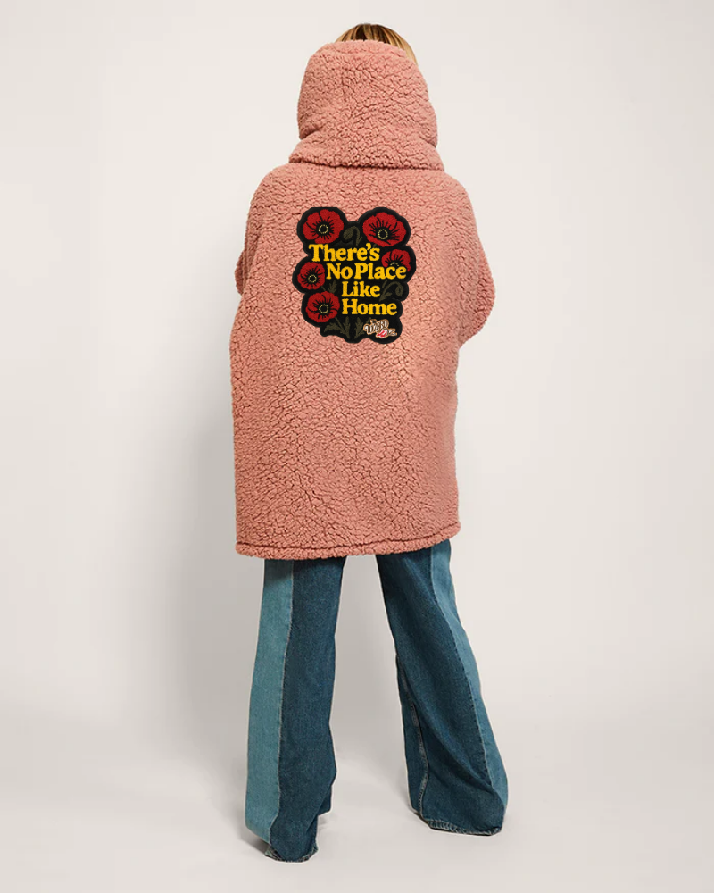 Person wearing a pink fleece jacket with a graphic design on the back against a white background