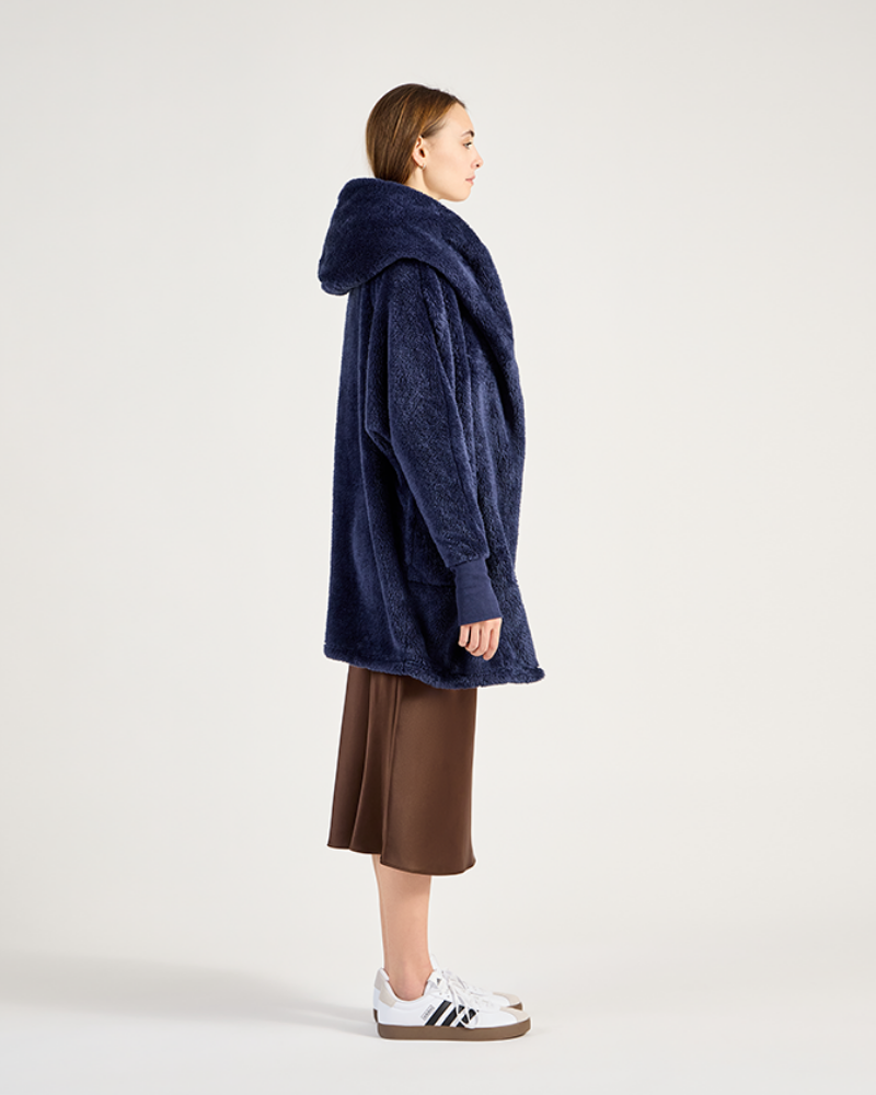 Person wearing a blue hooded coat on a white background