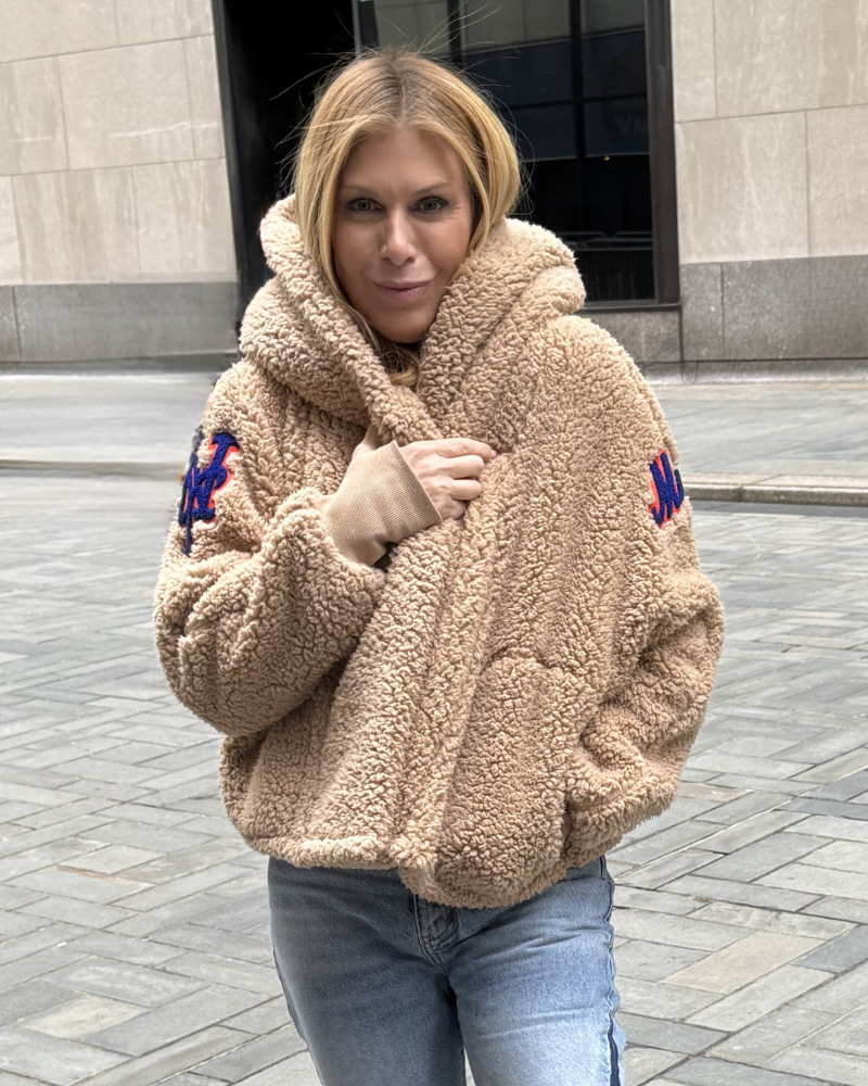 Woman wearing a beige sherpa jacket with patches on a city street.|Jill: 5'6" in size XS/S