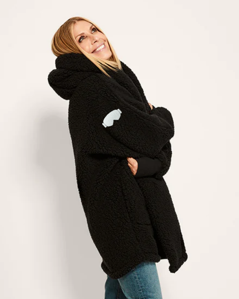 Woman wearing a black hoodie with a white heart design on a plain background