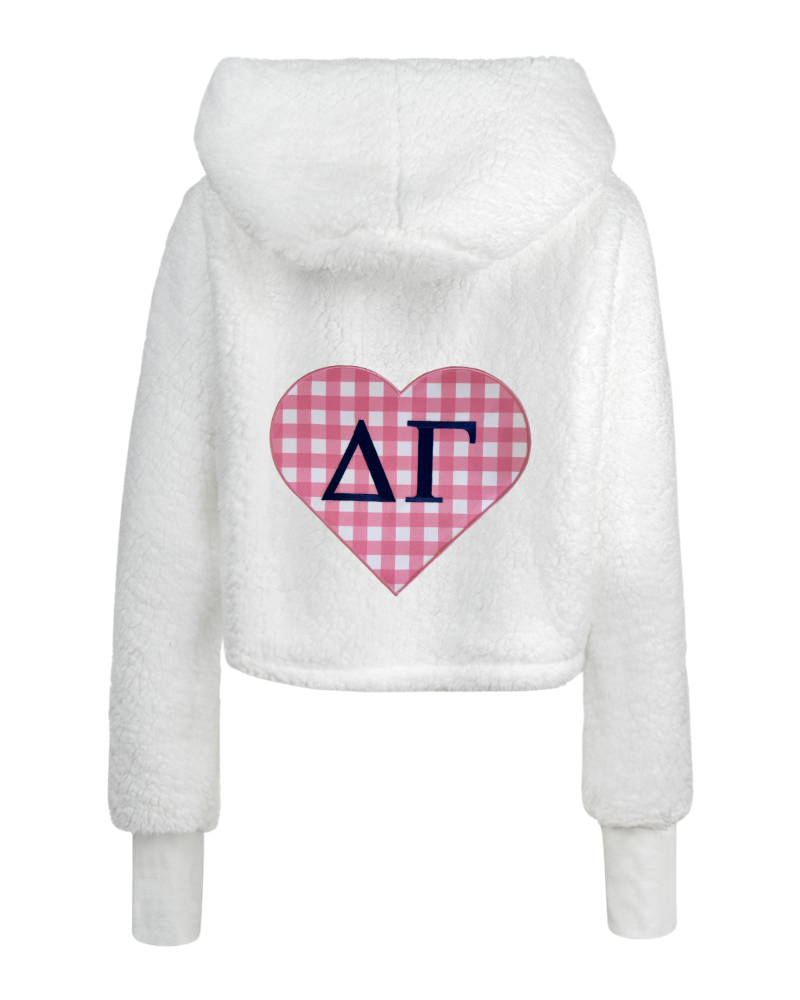 White fuzzy cropped hoodie with a pink and white gingham heart on the back featuring navy blue Greek letters Delta Gamma.
