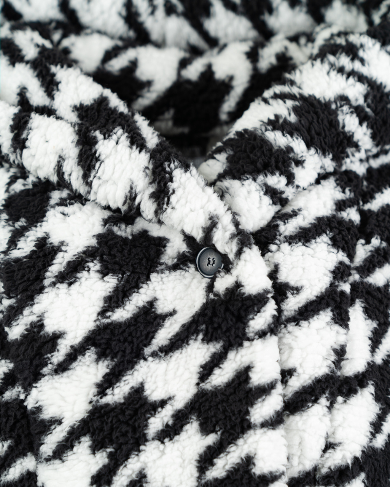 Close-up of a black and white checkered fabric with a button.