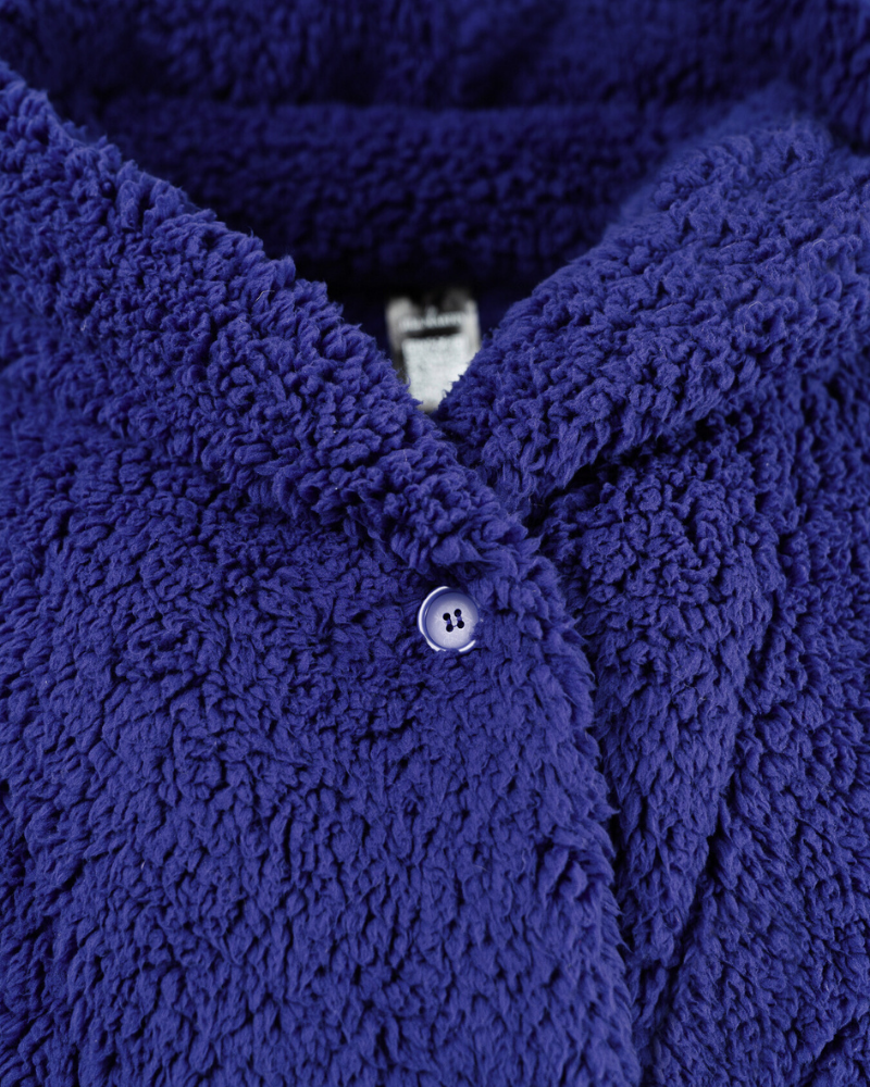 Close-up of a blue textured garment with a button