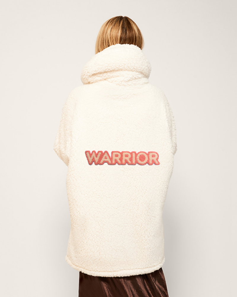 Person wearing a white vest with 'WARRIOR' printed on the back against a light gray background