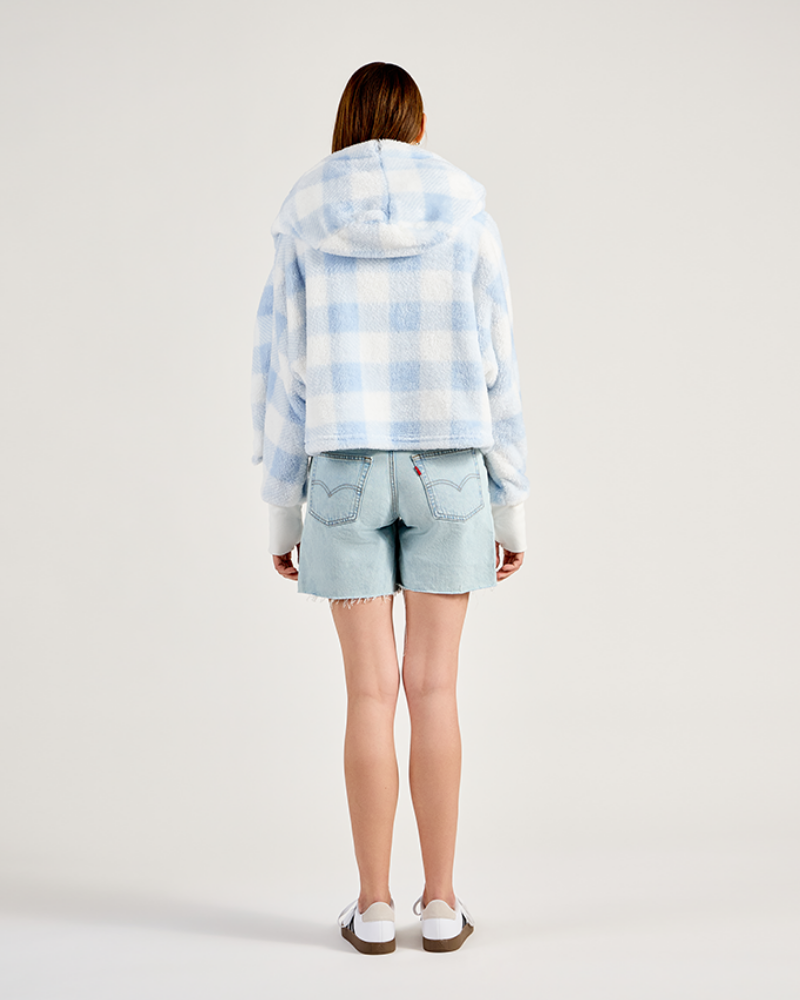 Person wearing a light blue and white checkered hoodie and denim shorts on a plain background|Model: 5'11" in size XS/S