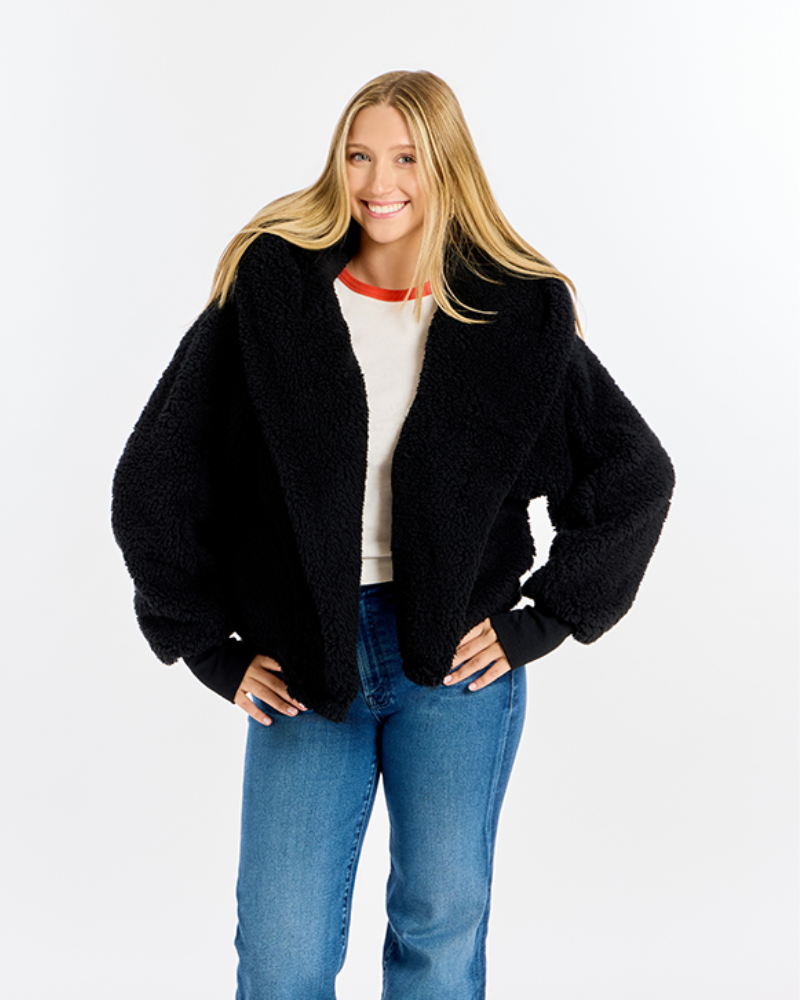 Black sherpa lounger cropped jacket on a woman wearing jeans against a white background